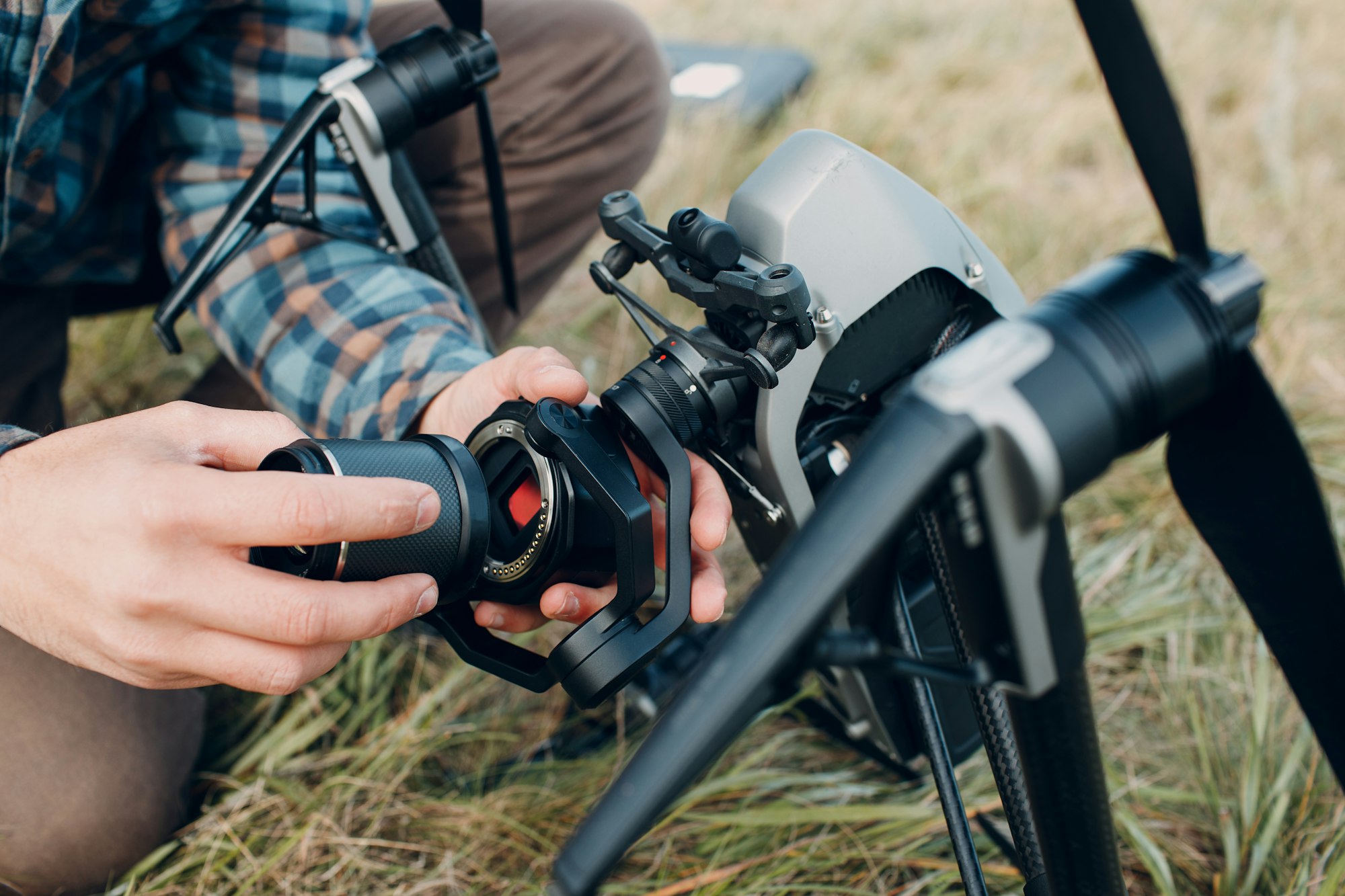 Man pilot checking quadcopter drone before aerial flight and filming.