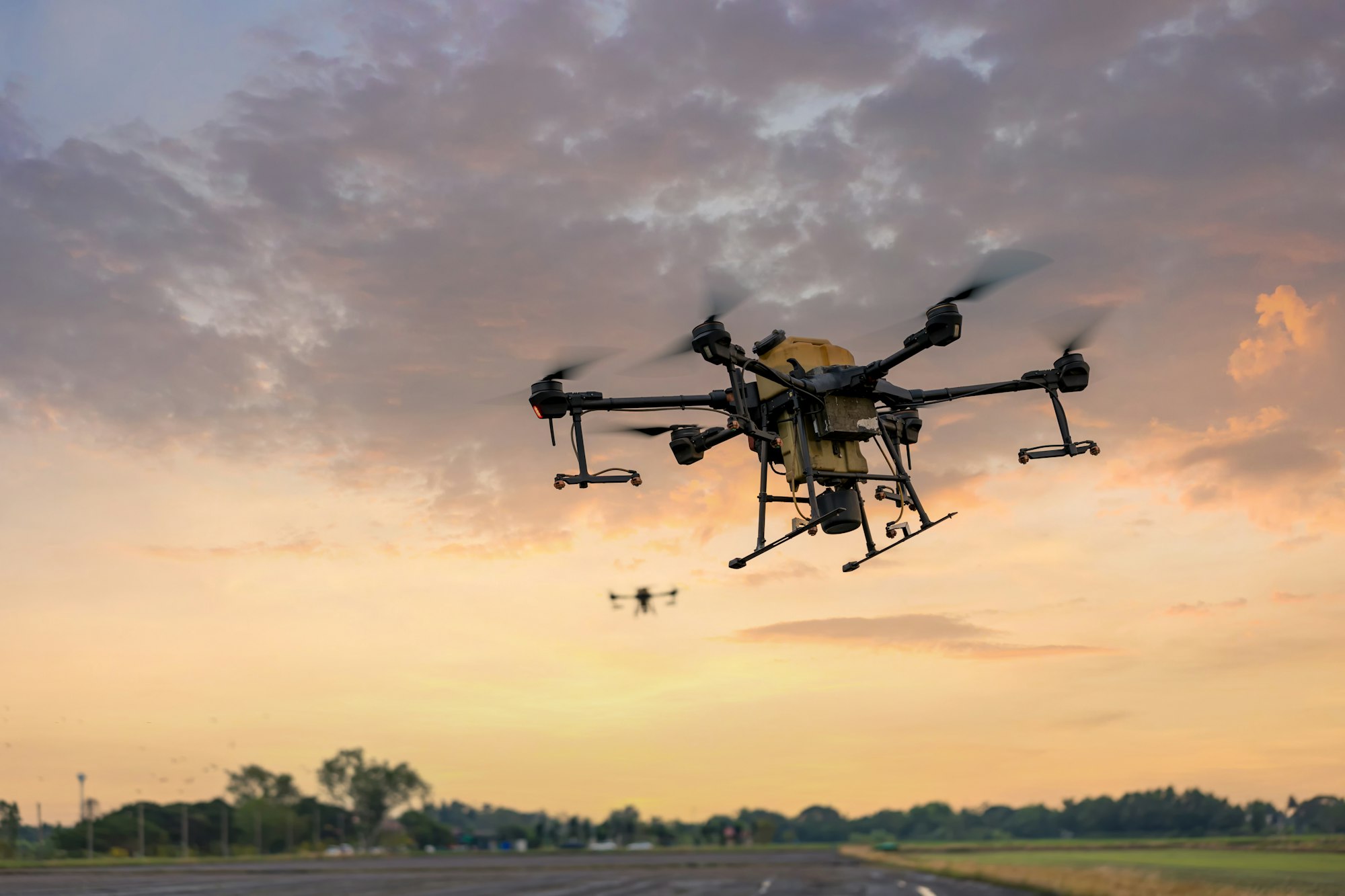 Modern smart farm with drone. Agriculture drone fly to Ready spray fertilizer on the rice fields.